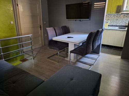 a room with a table and chairs and a tv at Apartmani Pelivan in Soko Banja