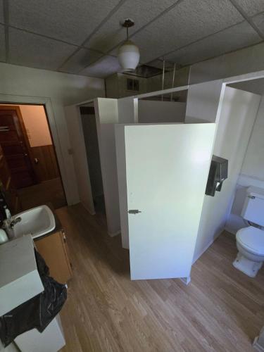 a white bathroom with a toilet and a sink at Coal Branch Hotel & Restaurant in Coalspur