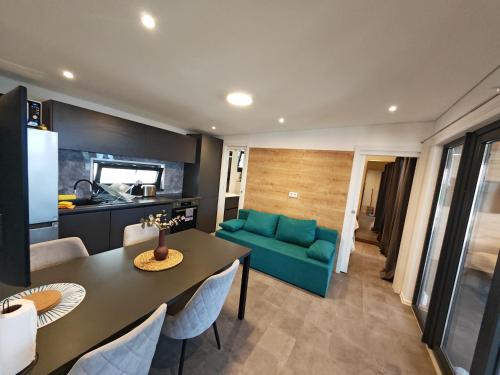 a living room with a table and a green couch at Sea view BluEscape by Vellaris, Luxury Mobile Home in Mali Lošinj