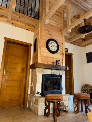 a room with a fireplace with a clock on the wall at Princess Nina Kolašin in Kolašin