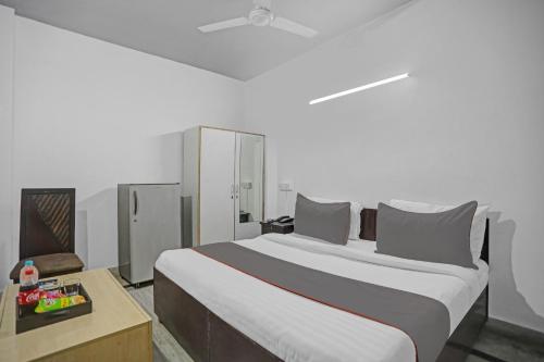 a bedroom with a large bed and a chair at Hotel O The Premium Villa in New Delhi