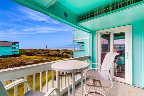 a blue house with a table and chairs on a balcony at Seaspray 242 in Atlantic Beach
