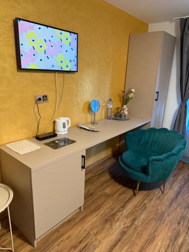a room with a desk and a green chair at Apartmány Karlov Dvor in Trnava