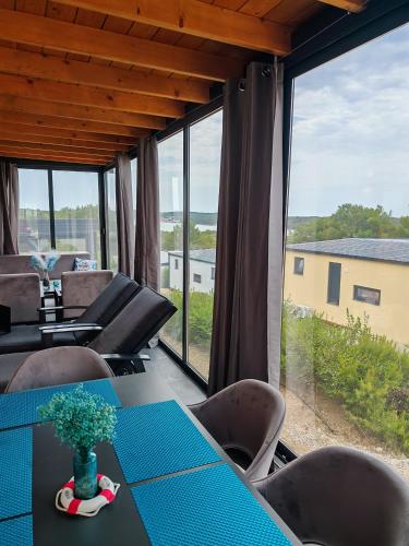 a dining room with a table and chairs and large windows at Sea view BluEscape by Vellaris, Luxury Mobile Home in Mali Lošinj