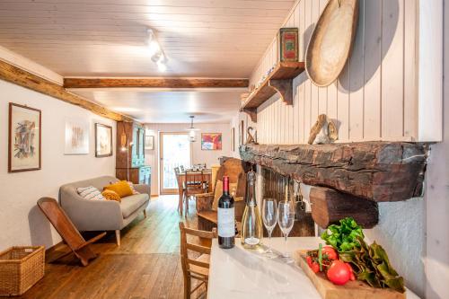 a kitchen and living room with a table with a bottle of wine at Spitzenhaus Val Onsernone - Happy Rentals in Vergeletto