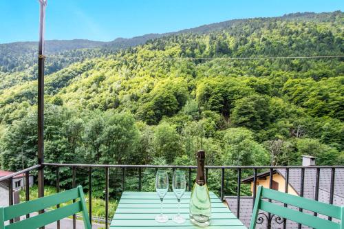 a blue table with wine glasses on a balcony at Spitzenhaus Val Onsernone - Happy Rentals in Vergeletto