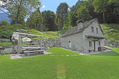 an old stone house with a picnic table in a yard at Rustico Alla Bolla - Happy Rentals in Frasco