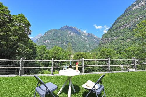 a table and chairs on a lawn with mountains in the background at Rustico Alla Bolla - Happy Rentals in Frasco