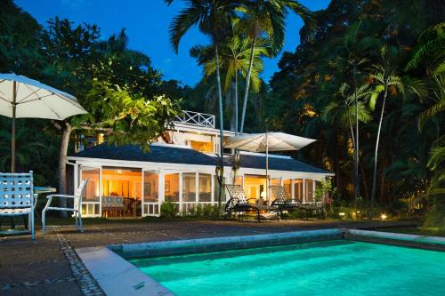 a house with a swimming pool in front of a house at Round Hill Hotel & Villas in Montego Bay