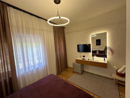 a bedroom with a bed and a tv and a mirror at Manga guesthouse in Gjirokastër