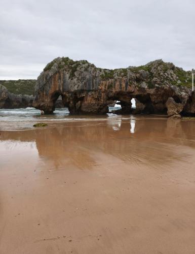 an archway in the rocks on the beach at Casa Milu in Armiello