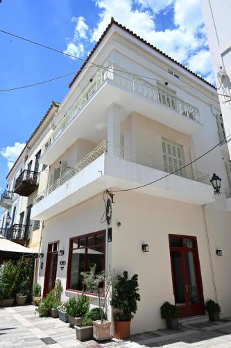 a white building with a balcony on top at Porto Nafplio in Nafplio