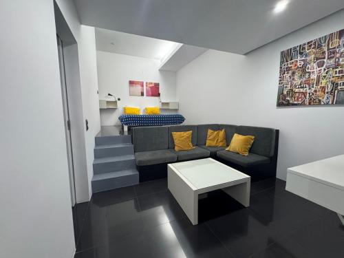 a living room with a couch and yellow pillows at Sea Breeze Studios in Porto da Cruz
