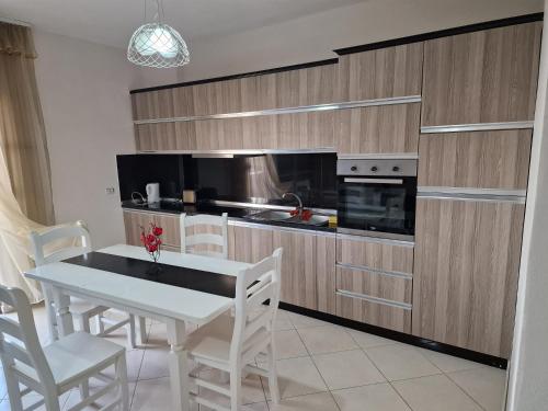 a kitchen with a white table and chairs and a kitchen with a stove at DURRES SEA SIDE Big Family Apartament in Durrës