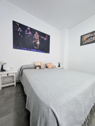 a bedroom with a large bed with a large picture on the wall at A Jerez Apartamentos in Jerez de la Frontera