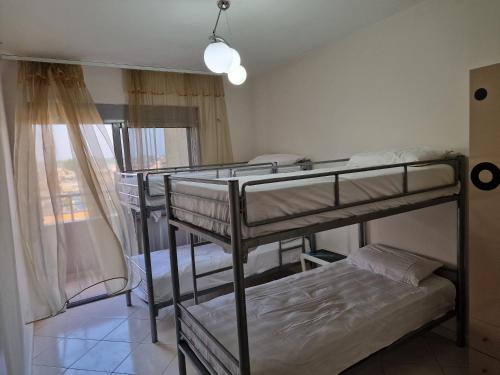 a room with three bunk beds and a window at DURRES SEA SIDE Big Family Apartament in Durrës