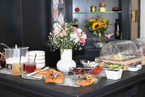 a table with food and a vase of flowers at Porto Nafplio in Nafplio
