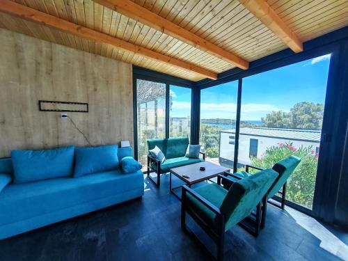 a living room with a blue couch and chairs at Sea view Anika by Vellaris, Luxury Mobile Home in Mali Lošinj