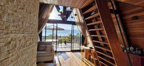 a living room with a chair and a glass door at Cabana Sol do Norte in Brumadinho