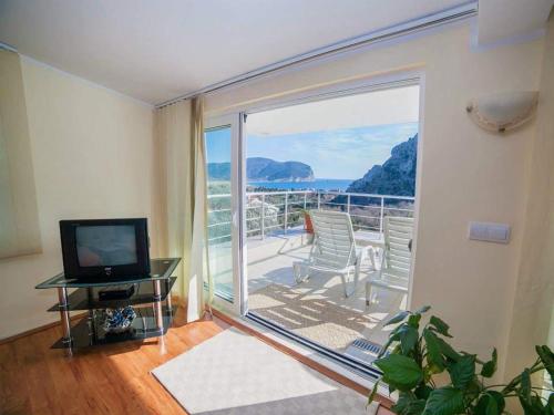 a living room with a balcony with a view of the ocean at Villa INA in Kaluđerac