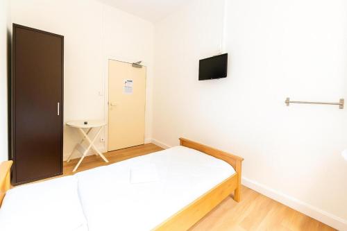 a bedroom with a bed and a tv on a wall at Hôtel Le Paris Brest in Lens