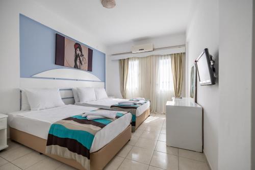 a bedroom with two beds and a tv in it at MaxSea Beach Hotel in Bodrum City