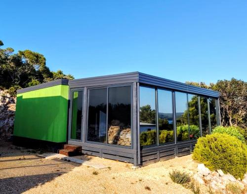 a green and gray house with glass windows at Sea view Anika by Vellaris, Luxury Mobile Home in Mali Lošinj