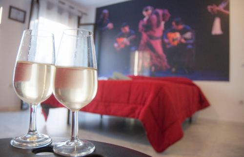 two glasses of white wine sitting on a table at A Jerez Apartamentos in Jerez de la Frontera