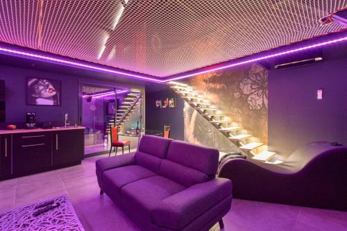 - un salon avec un canapé violet et un escalier dans l'établissement Espace évasions Loft love LOVE ROOM, à Toulouse