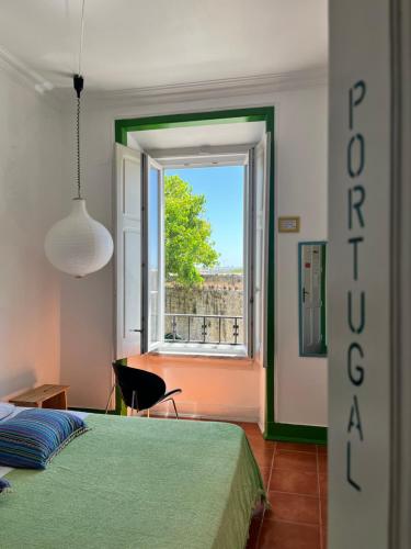 a bedroom with a green bed and a window at Peniche Hostel in Peniche