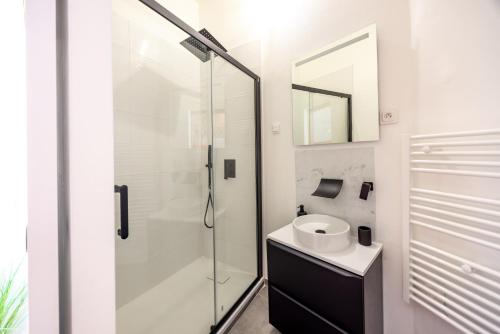 une salle de bain avec une douche en verre et un lavabo dans l'établissement Gîte du Bon-Secours, à Saint-Malo