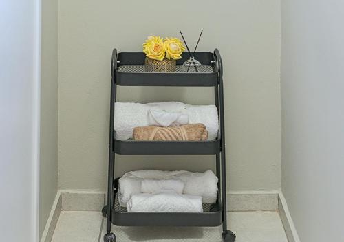 Un toallero con toallas y una cesta de flores. en Charming Studio & Backup Power, en Johannesburgo