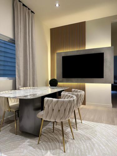 a dining room with a table and chairs and a tv at Free Parking 2 Bedroom The Comfy Haven in Pittsburgh