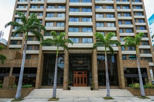 a building with palm trees in front of it at JW Marriott Caracas in Caracas