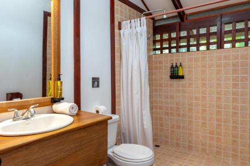 a bathroom with a sink and a toilet and a shower at Namuwoki Lodge in Puerto Viejo