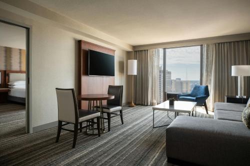 a hotel room with a bed and a couch and a table at Kansas City Marriott Downtown in Kansas City