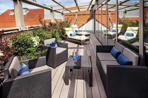 a patio with couches and a table on a balcony at Hotel Luc, Autograph Collection in Berlin