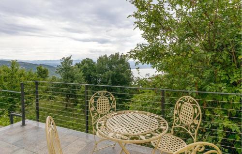 a patio with two chairs and a table and a fence at Beautiful Home In Dobrec With Kitchen in Dobreć