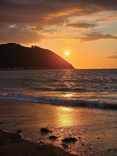 a sunset on the beach with the sun setting at Foxes Hotel in Minehead