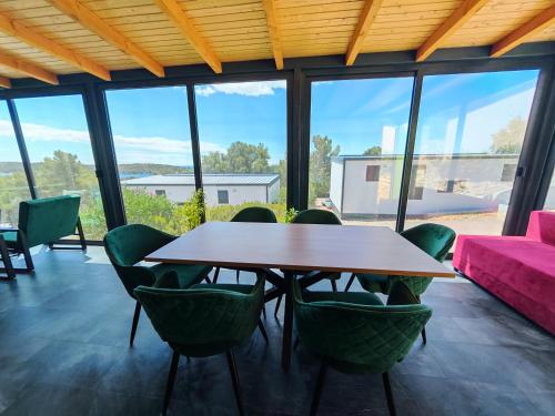 a dining room with a table and chairs and a couch at Sea view Anika by Vellaris, Luxury Mobile Home in Mali Lošinj