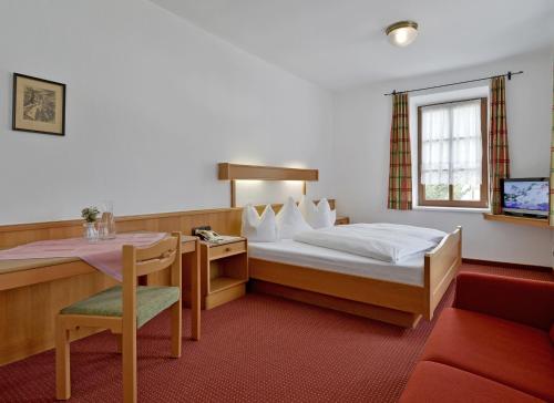 a hotel room with a bed and a table at Försterhaus & Haus Andrea in Mayrhofen