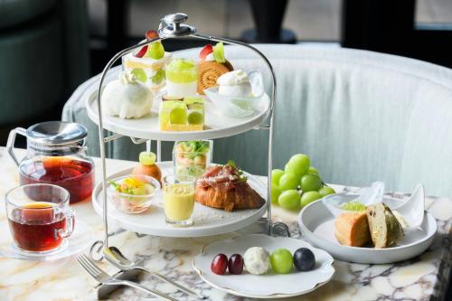 a three tiered tray of food on a table at Sheraton Kagoshima in Kagoshima
