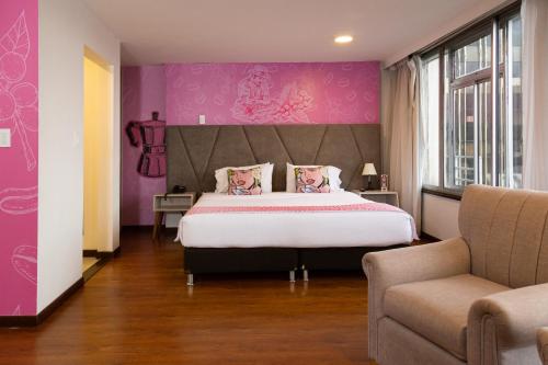 a bedroom with a large bed and a purple wall at Pop Art Hotel Las Colinas Manizales in Manizales