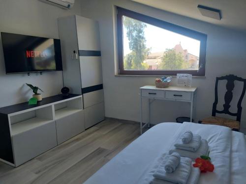 a bedroom with a bed and a tv and a window at Oasi Relax in Borgo Isonzo