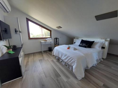 a bedroom with a large white bed and a window at Oasi Relax in Borgo Isonzo