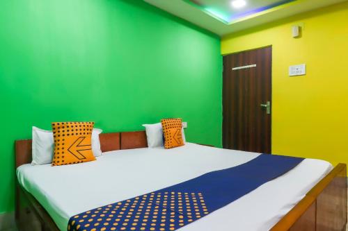 a bedroom with green and yellow walls and a bed at Hotel O Bright in Jamshedpur