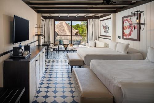 a hotel room with two beds and a television at El Beso Adults Only at Ocean Riviera Paradise All Inclusive in Playa del Carmen