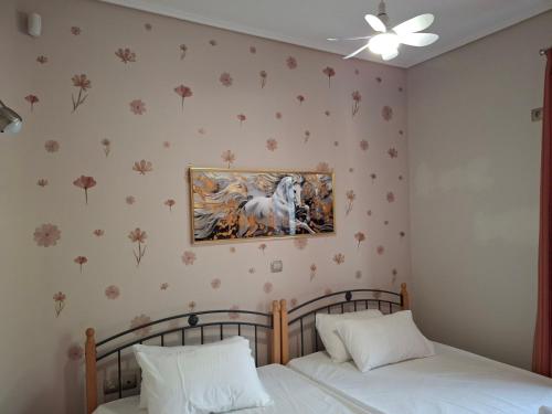 a bedroom with two beds and a painting on the wall at Roe Sea View in Kyparissia