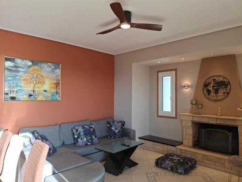 a living room with a couch and a ceiling fan at Roe Sea View in Kyparissia