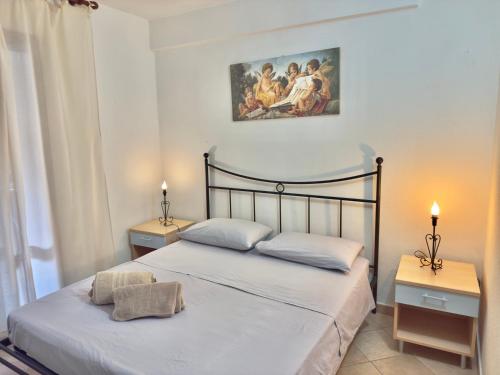 a bedroom with a bed with two night stands and a painting at Appartamento Rosè in San Teodoro